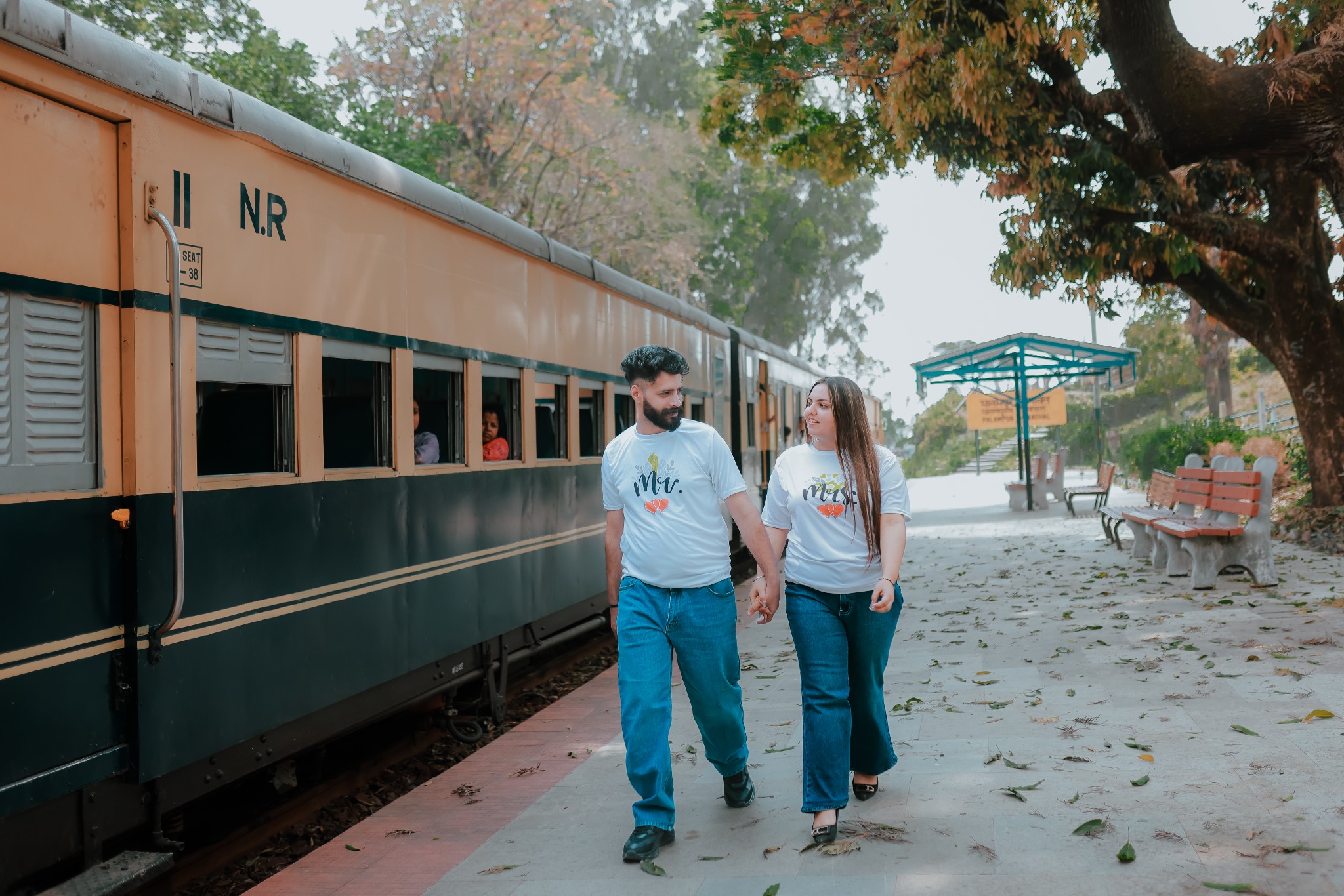 Couple walking beside a vintage train for pre-wedding shoot